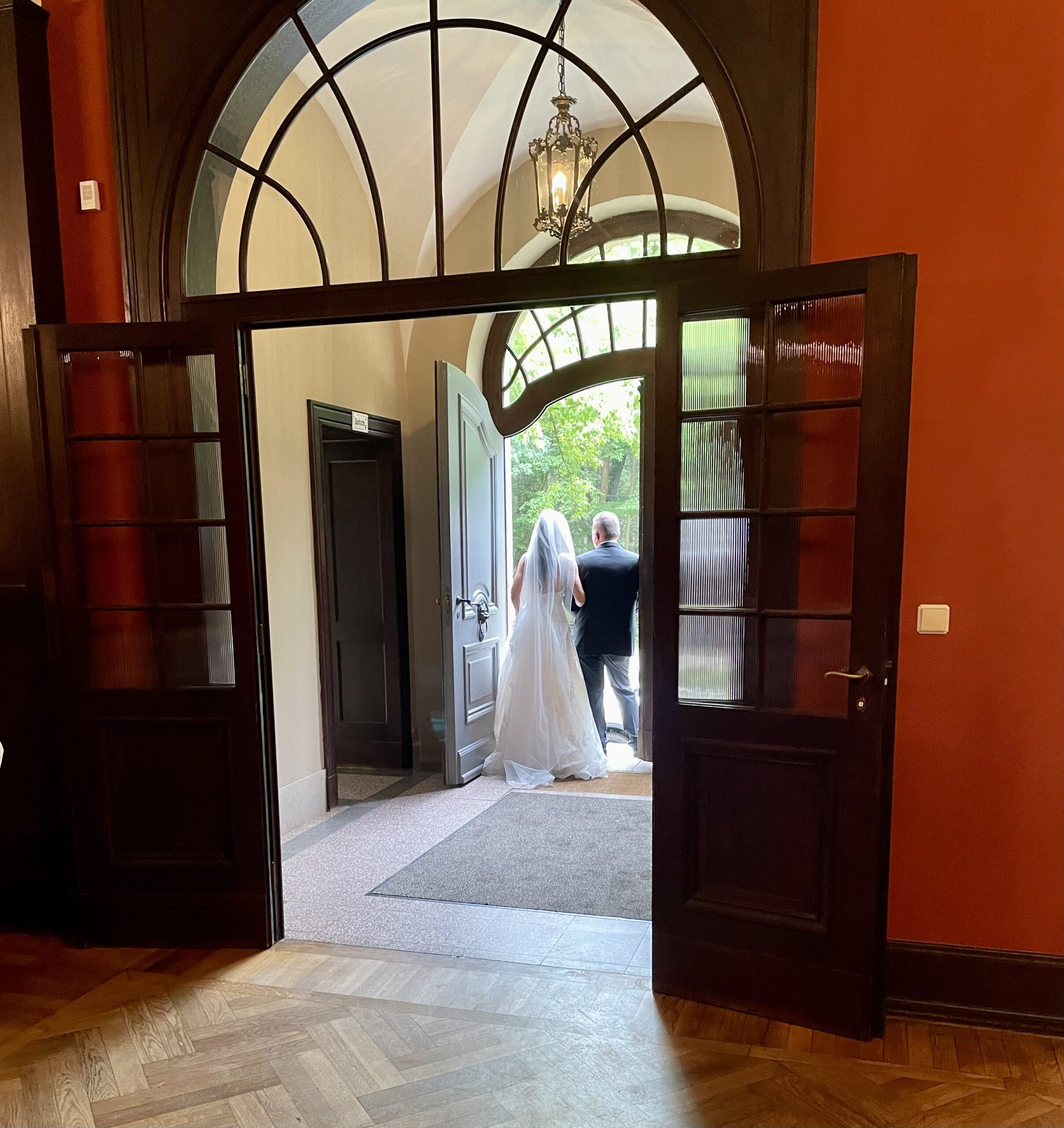 Braut mit Vater am Eingangsportal